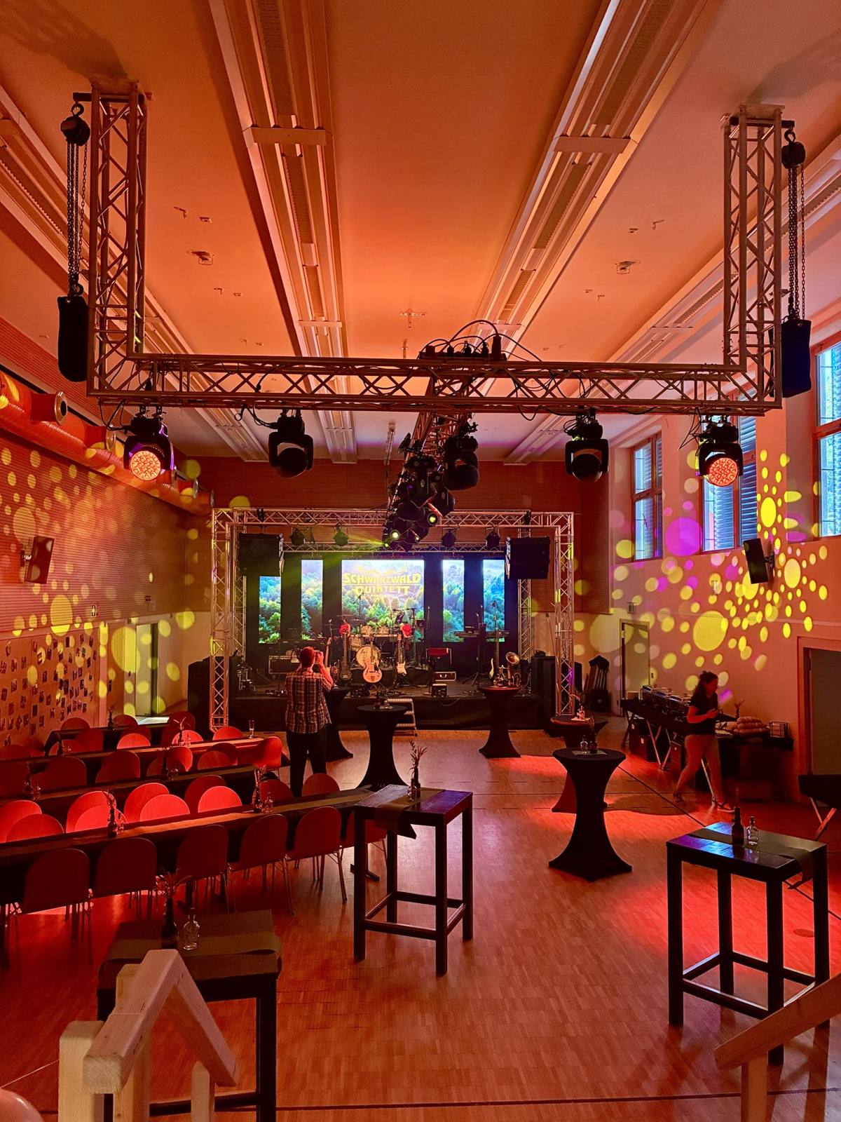 Halle mit Traversen, Moving Heads und LED-Wand vor dem Einlass