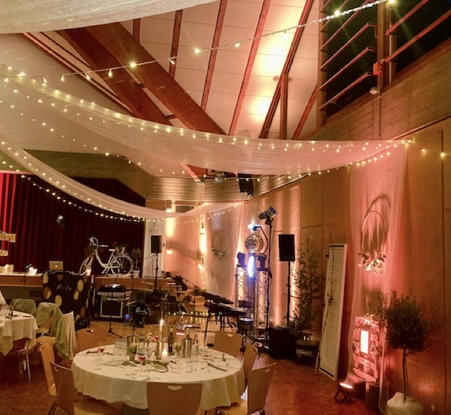 Festsaal mit Lichterketten, Stoffbahnen und Tontechnik für eine Hochzeit