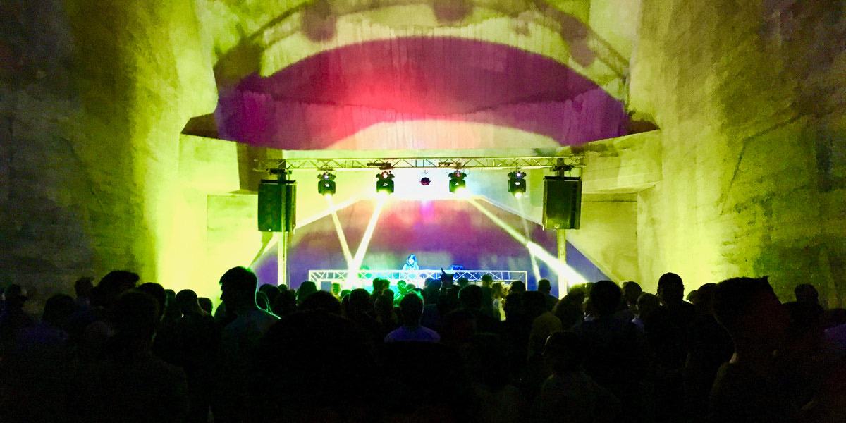 Elektroparty unter einer beleuchteten Staumauer, Bühne mit Lichtshow